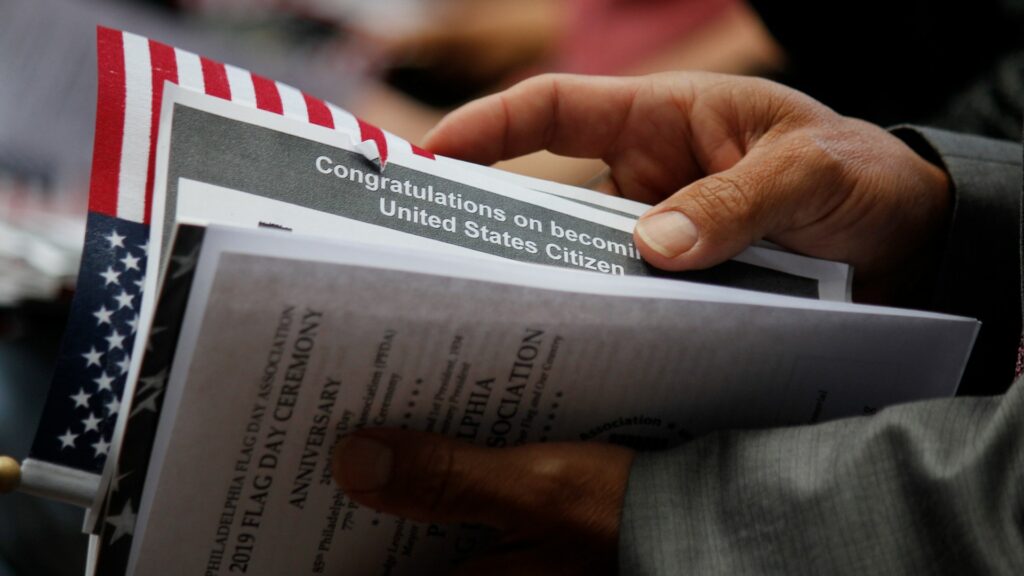 Close shot of naturalization paperwork and an American flag.